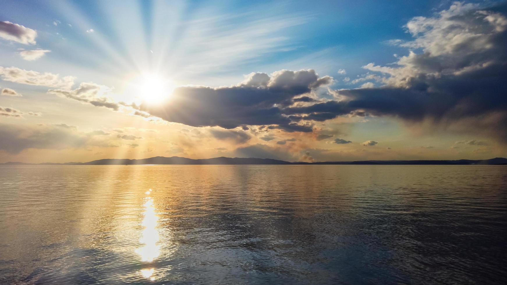 paesaggio marino con cielo nuvoloso colorato su un corpo d'acqua foto