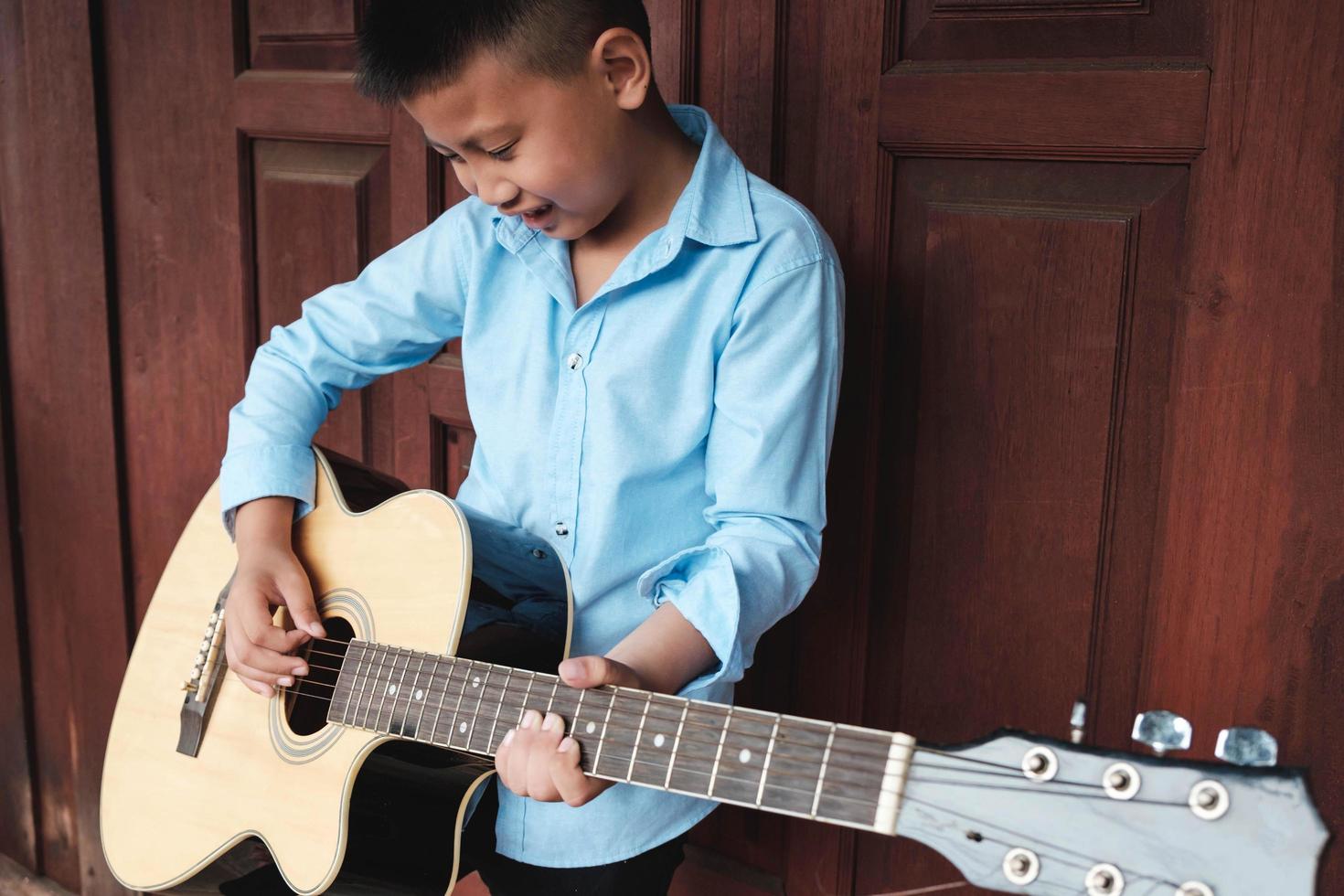 ragazzo che si diverte a suonare una chitarra foto