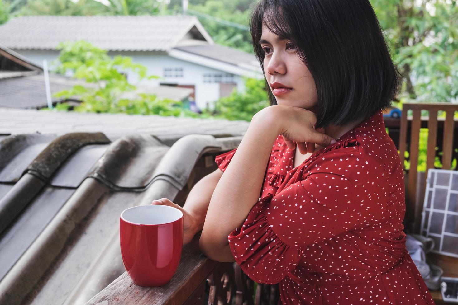 donna seduta con un caffè su una terrazza foto