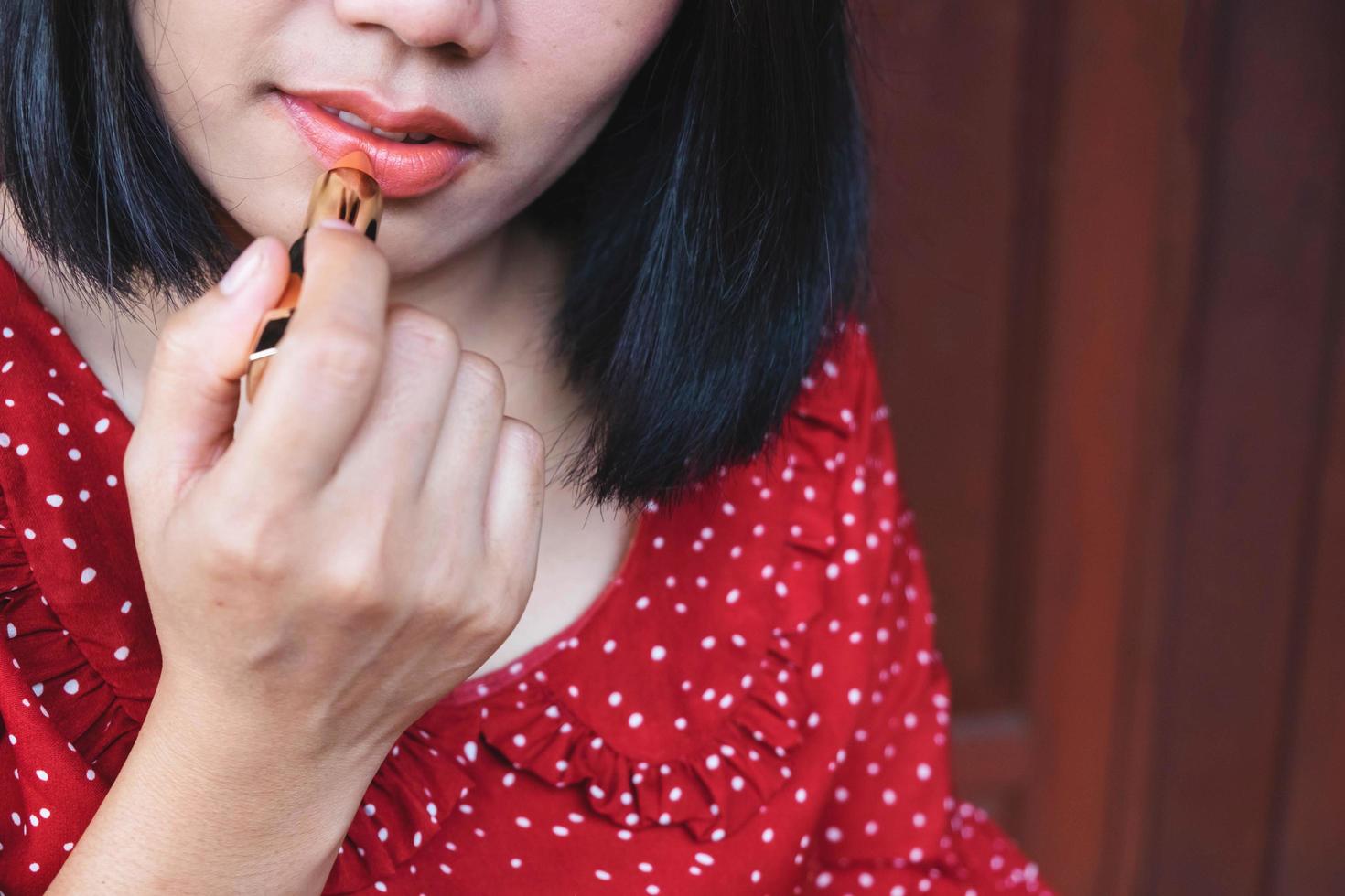 donna che applica il primo piano del rossetto foto