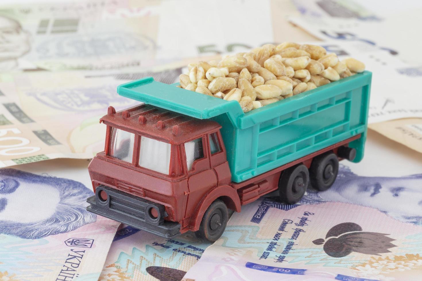 giocattolo camion caricato con Grano cereali in piedi su ucraino banconote foto