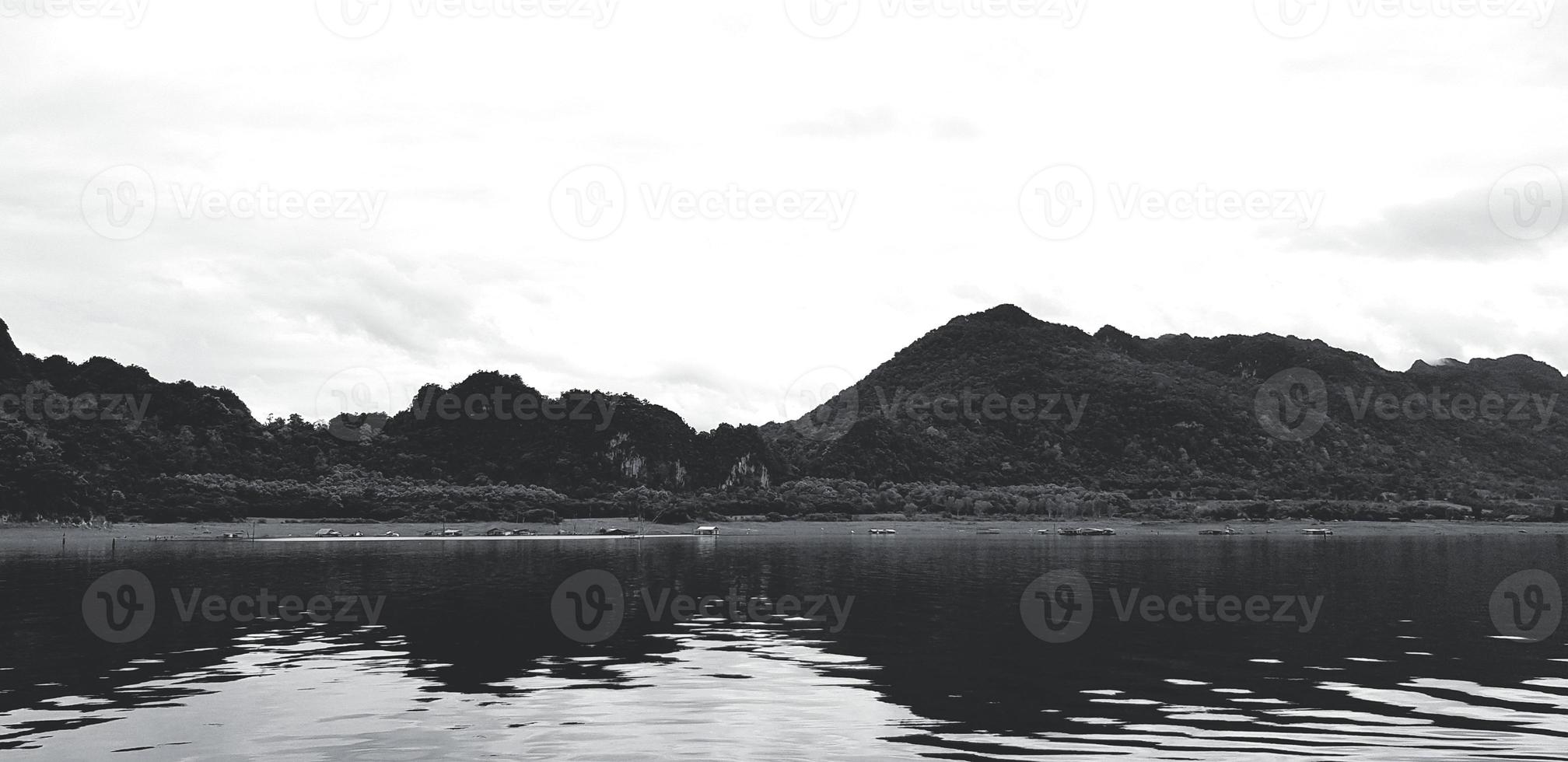 arte paesaggio di montagna Visualizza con fiume o lago, bianca cielo e riflessione su acqua a srinakarin diga, kanchanaburi nel nero e bianca tono. naturale sfondo e bellezza di natura nel monocromo. foto