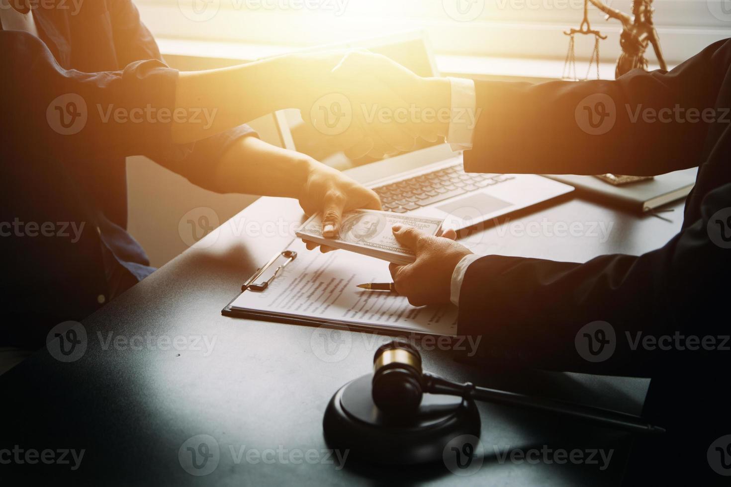 concetto di giustizia e diritto. il consulente legale presenta al cliente un contratto firmato con martelletto e diritto legale o una riunione del team legale presso uno studio legale in background foto