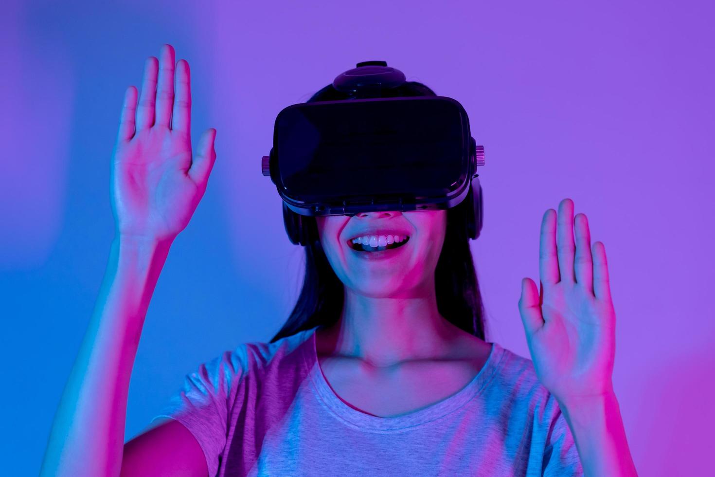 bella asiatico giovane donna toccante aria, indossare vr cuffia o visivo la realtà occhiali, bicchieri o gadget, giocare video gioco di simulatore futuro, futuristico mentre indossabile. tecnologia, isolato sfondo. foto