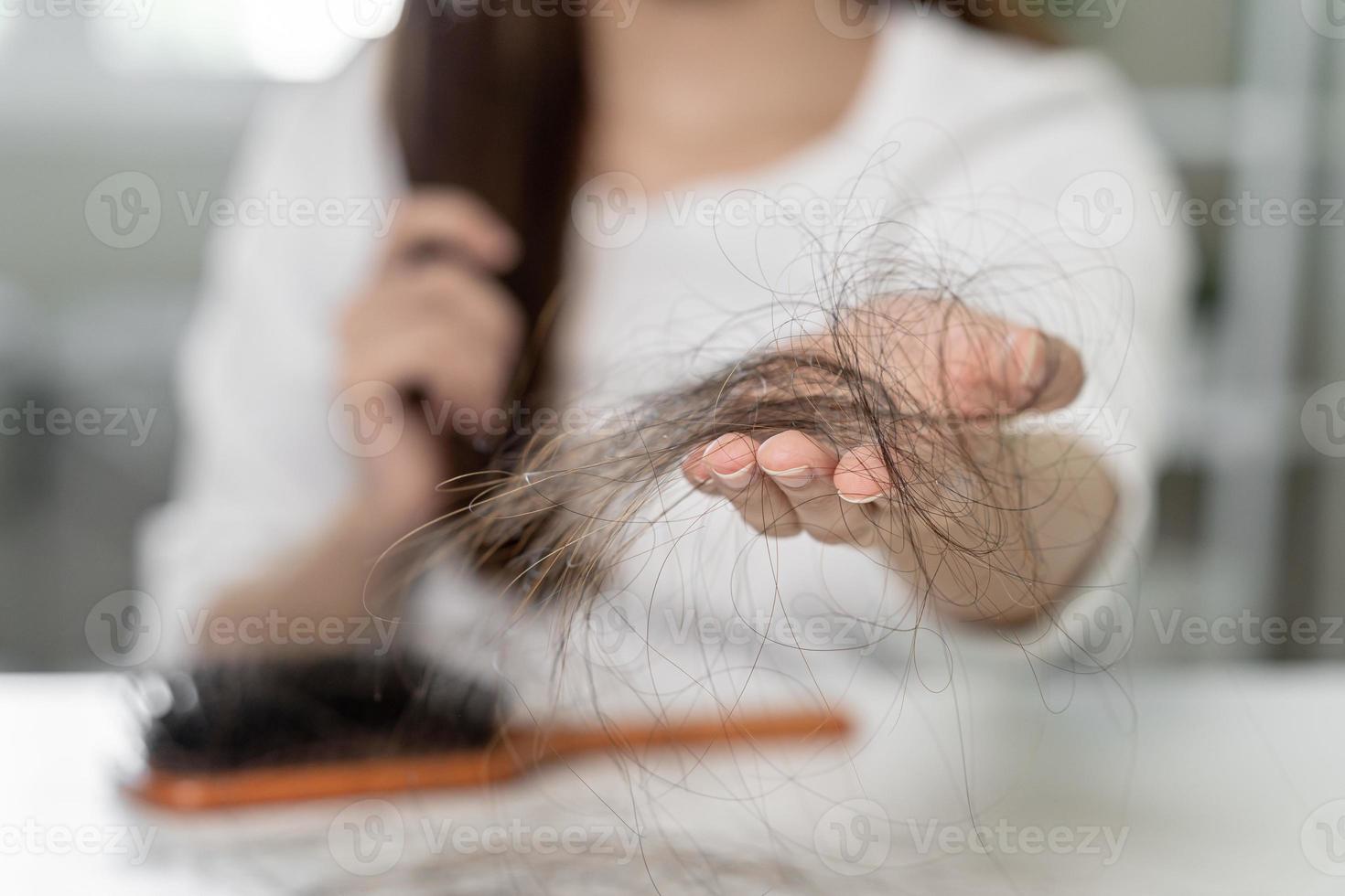 serio, preoccupato asiatico giovane donna, ragazza Tenere spazzola, mostrare sua pettine, spazzola per capelli con lungo perdita capelli problema dopo spazzolatura, capelli autunno su su sua mano nel vivente camera. Salute cura, bellezza trattamento. foto