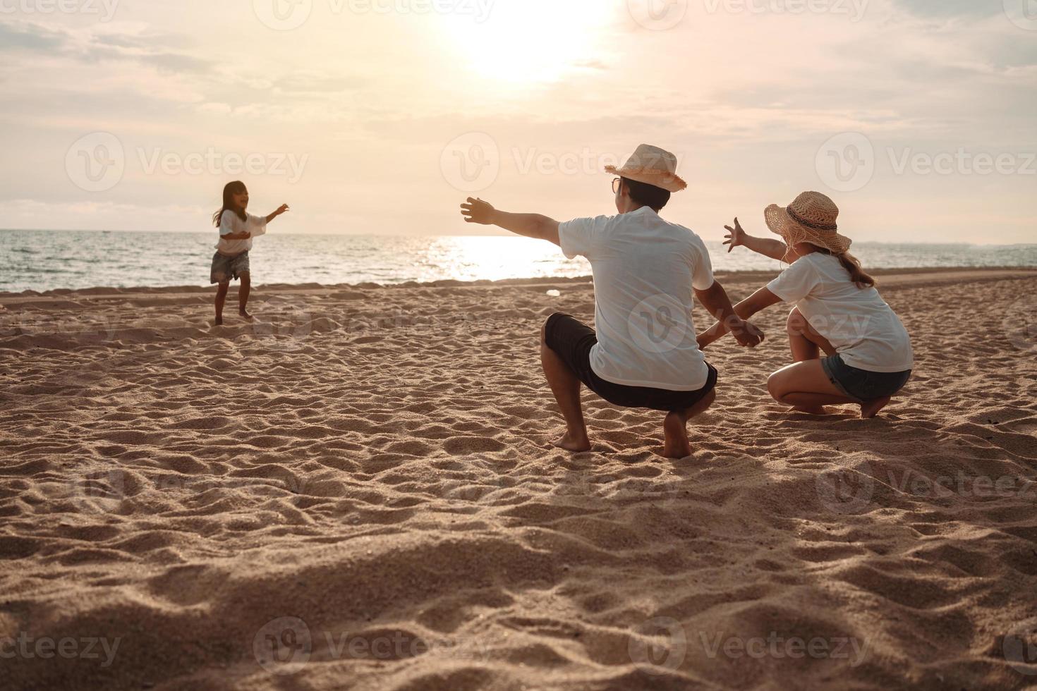 contento asiatico famiglia godere il mare spiaggia a consistente padre, madre e figlia avendo divertimento giocando spiaggia nel estate vacanza su il oceano spiaggia. contento famiglia con vacanze tempo stile di vita concetto. foto