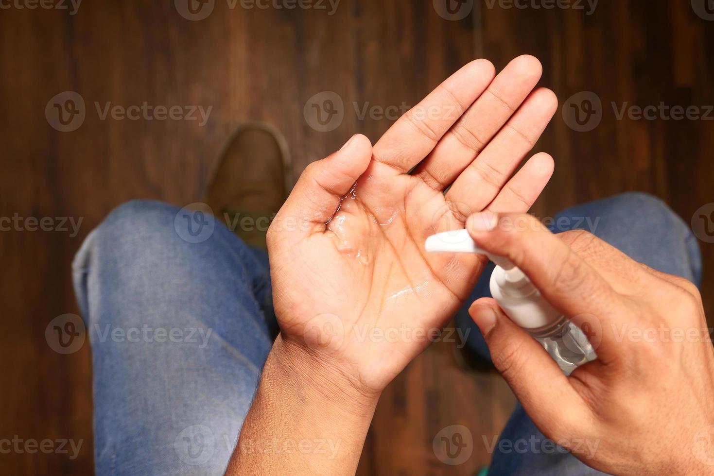 persona che utilizza disinfettante per le mani foto