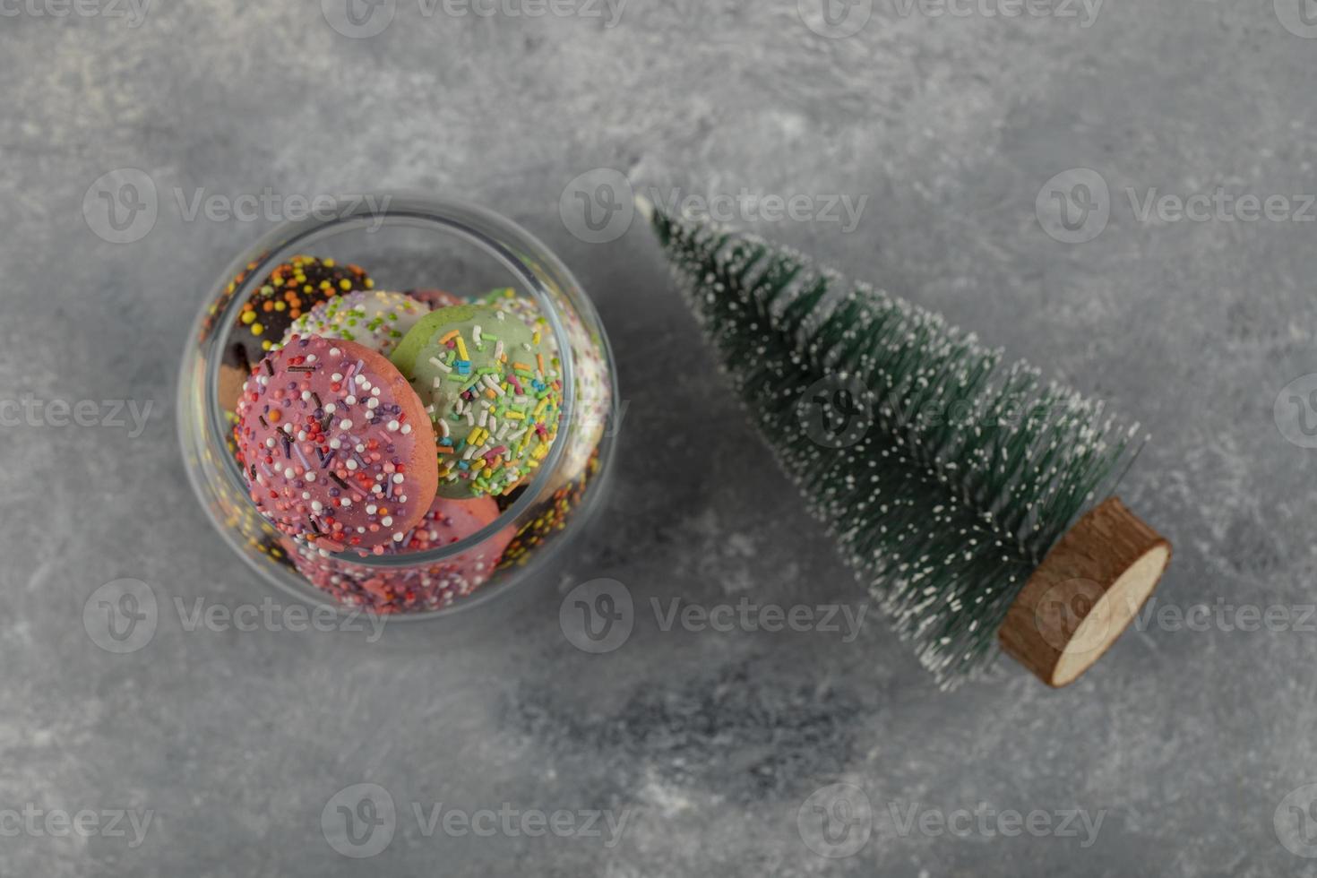 ciambelle dolci colorate con un albero di Natale giocattolo foto