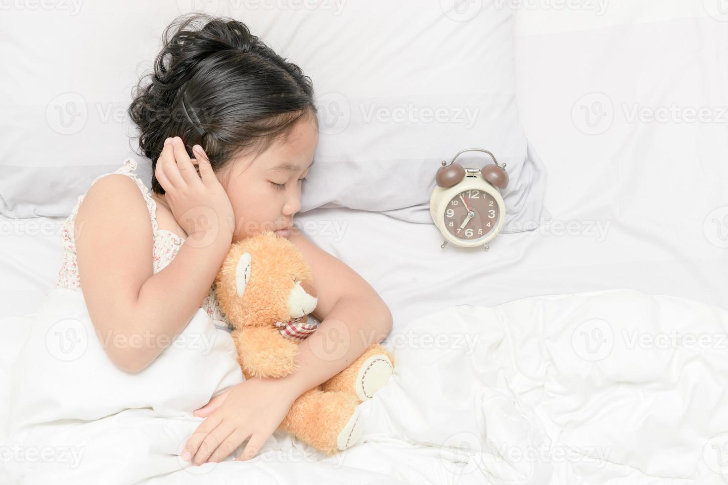 carino ragazza dormire e abbraccio trddy orso Bambola foto