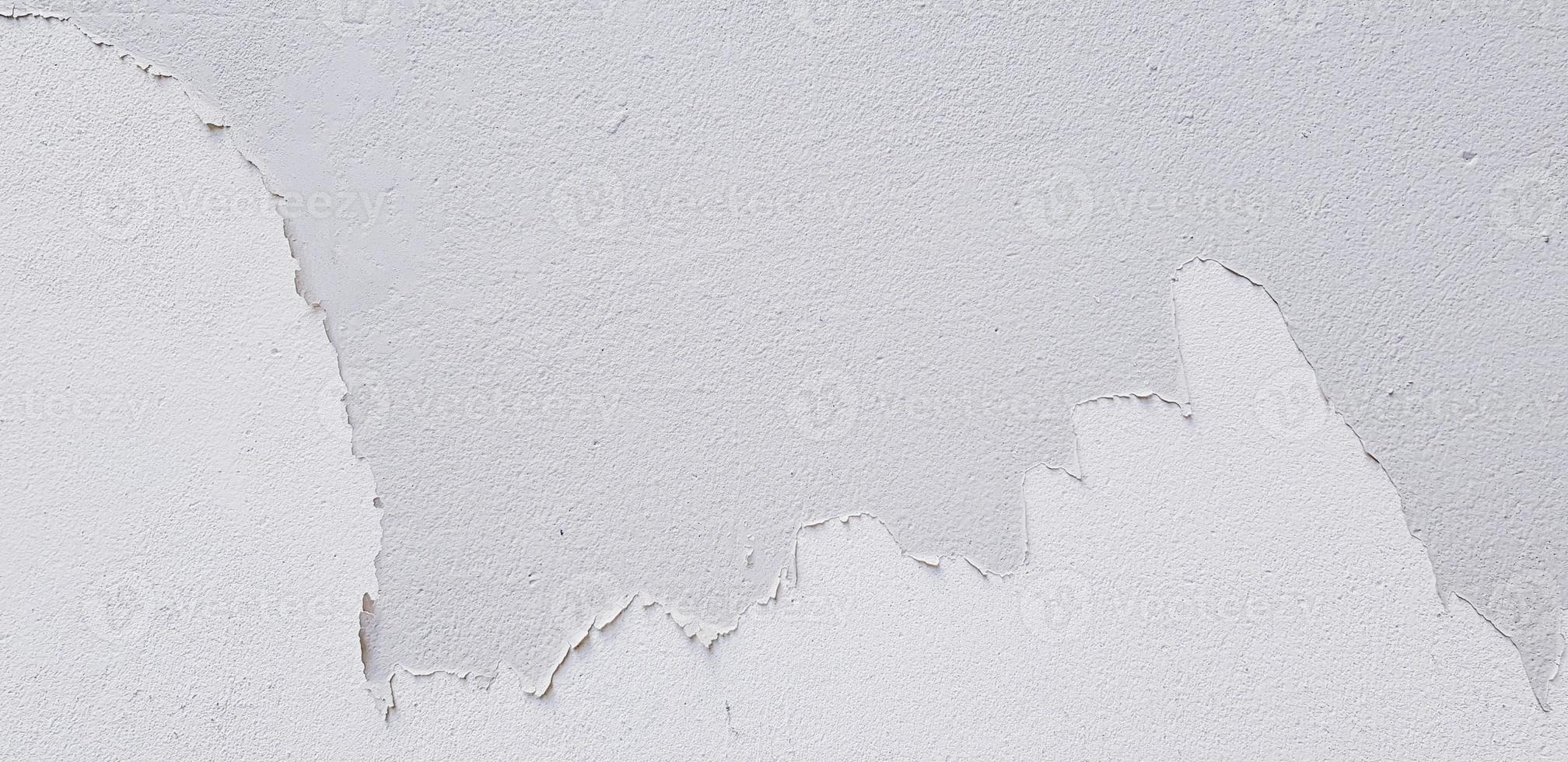 bianca dipinto Cracked su grigio cemento parete per sfondo con copia spazio. cattivo la pittura, danneggiato e vecchio grunge sfondo. foto