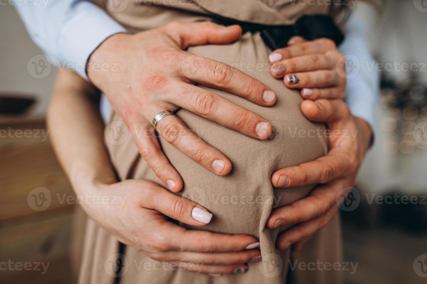 dell'uomo mani abbraccio un' pancia di il incinta donna foto