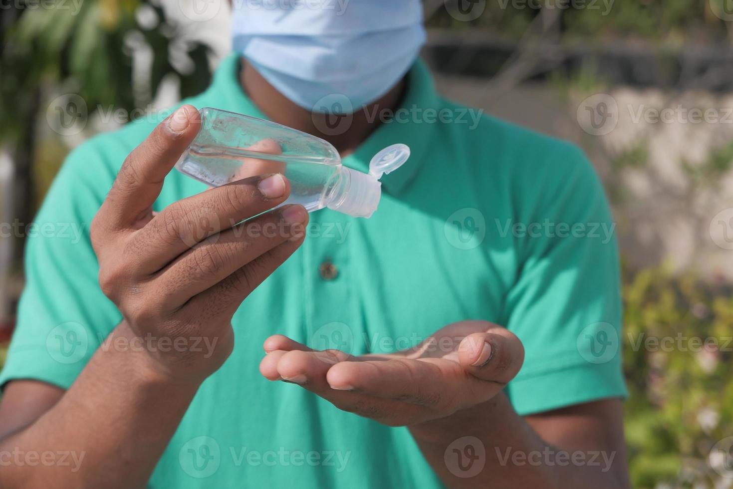 giovane uomo utilizzando disinfettante per le mani foto