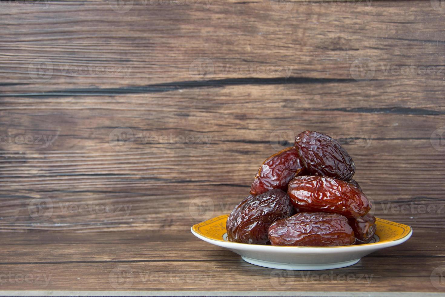 delizioso medjool date kurma o dolce secco date su un' piatto, con alcuni caduta a partire dal il piatto, come un' pasto per rottura il veloce, Ramadan kareem, vuoto spazio, copia spazio. foto