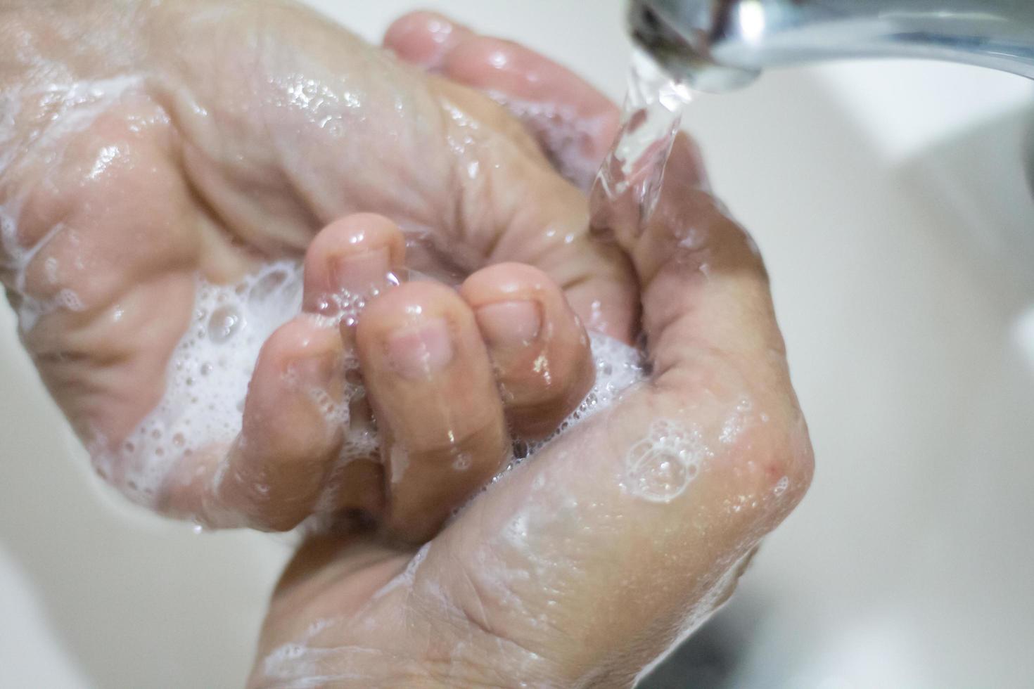 donna di mani lavaggio con sapone e acqua foto