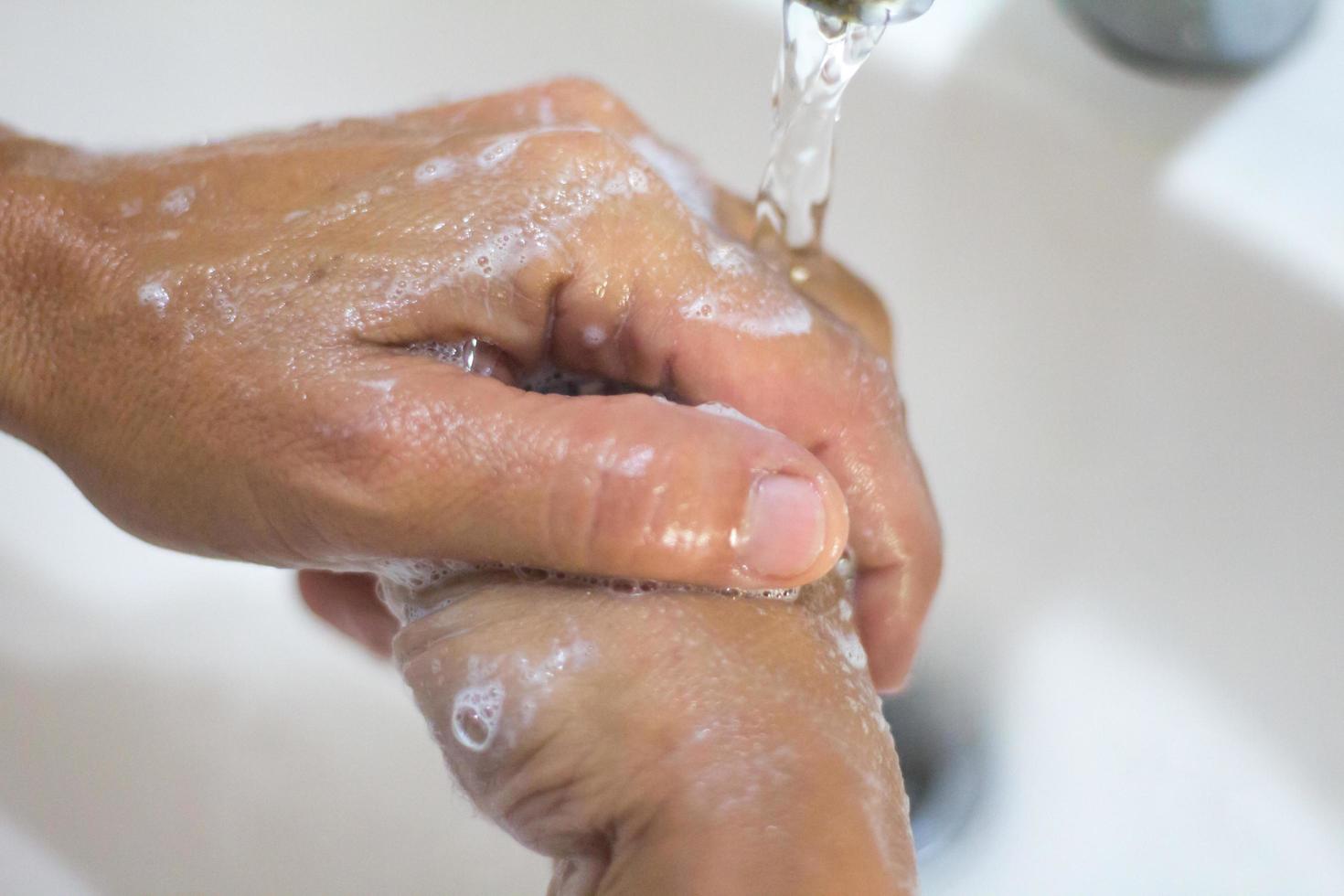 donna di mani lavaggio con sapone e acqua foto