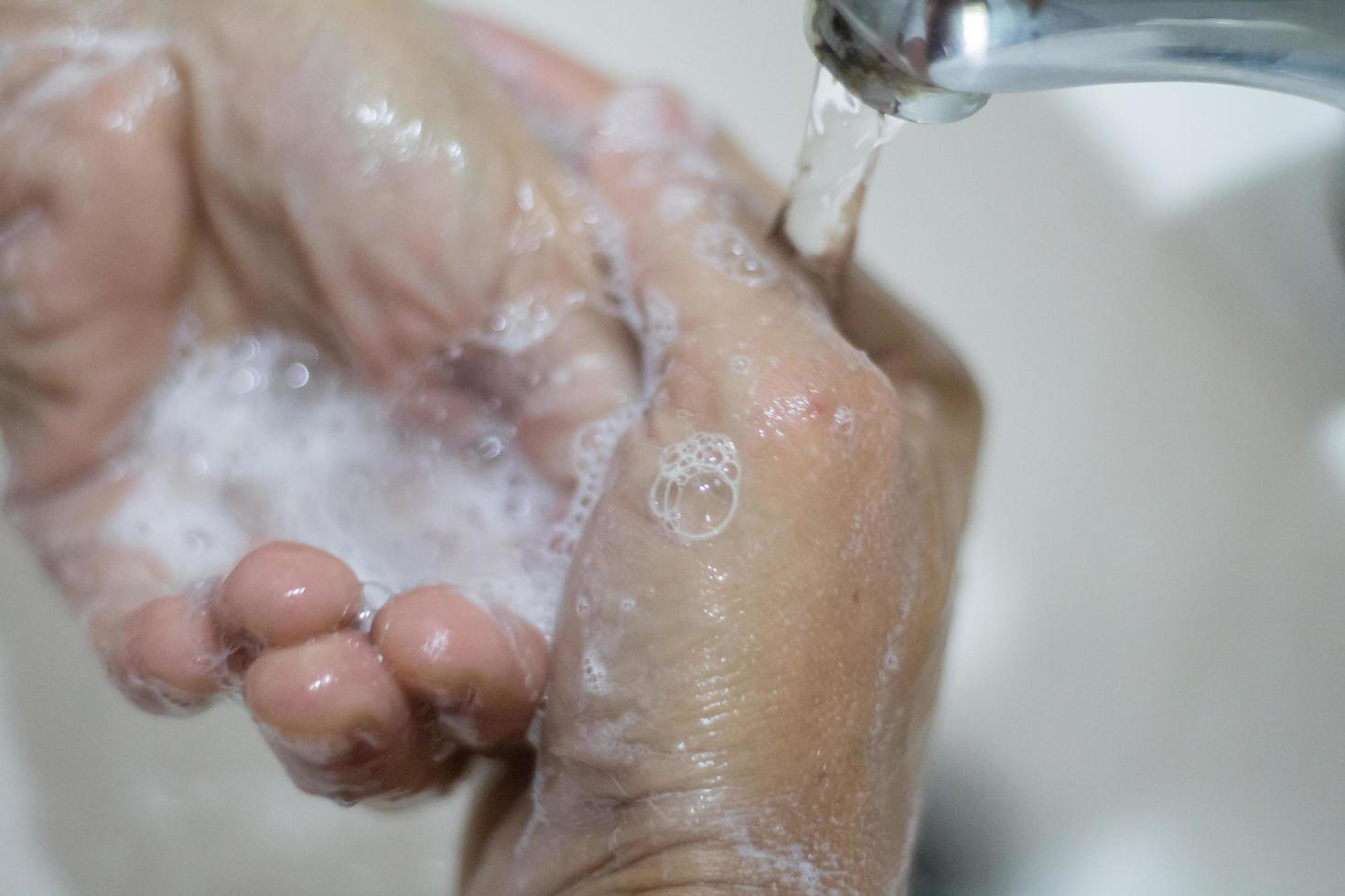 donna di mani lavaggio con sapone e acqua foto