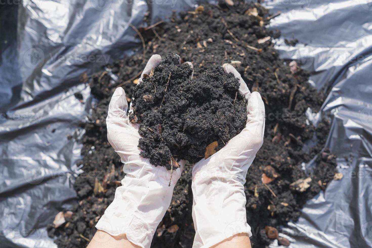 mani Tenere abbondanza suolo per agricoltura o preparazione per pianta analisi suolo campioni su mani con suolo terra sfondo. sporco qualità e agricoltura concetto. selettivo messa a fuoco su nero suolo nel davanti foto