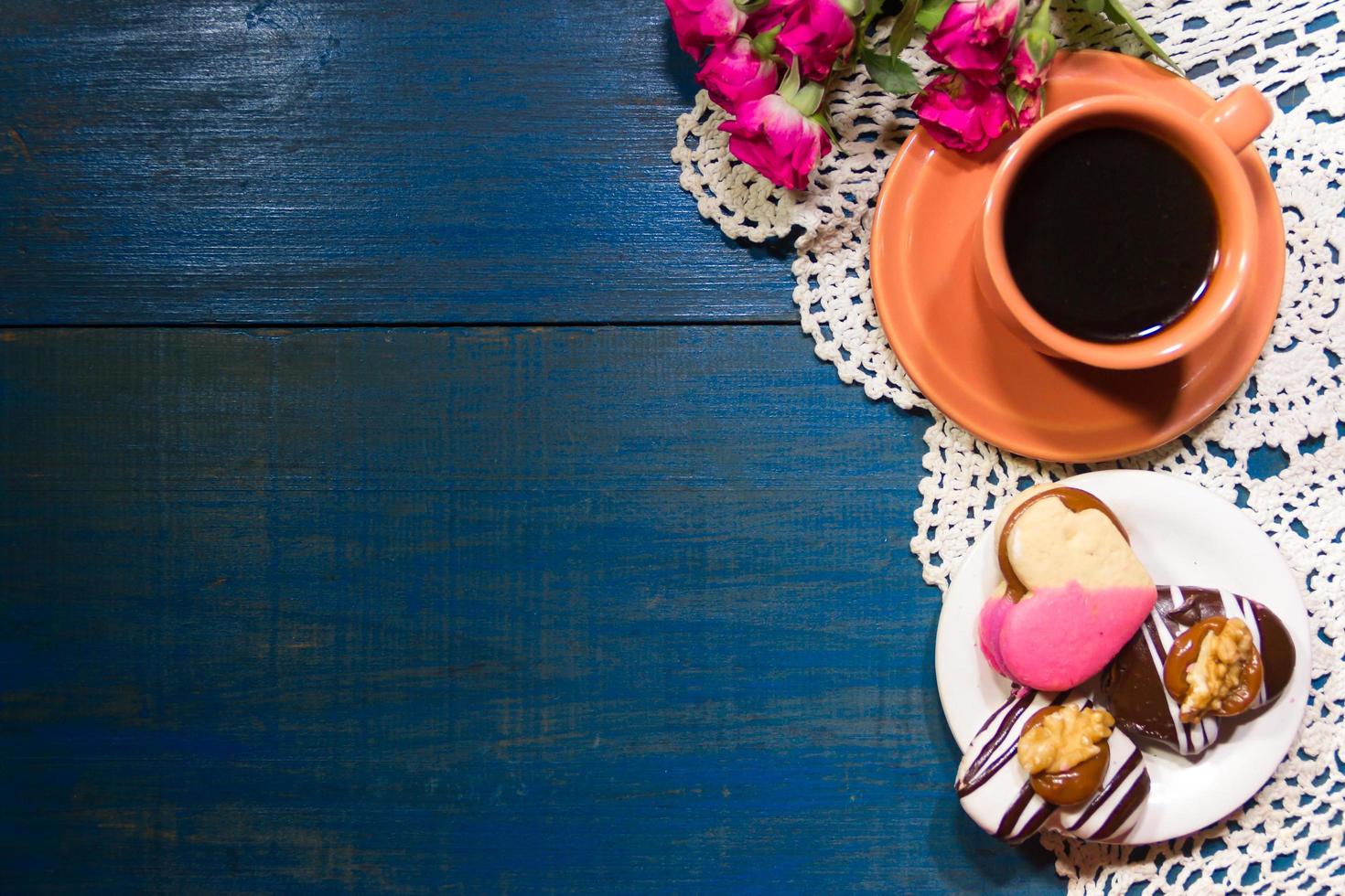 romantico fiori con caffè e dolce ossequi su il tavolo foto