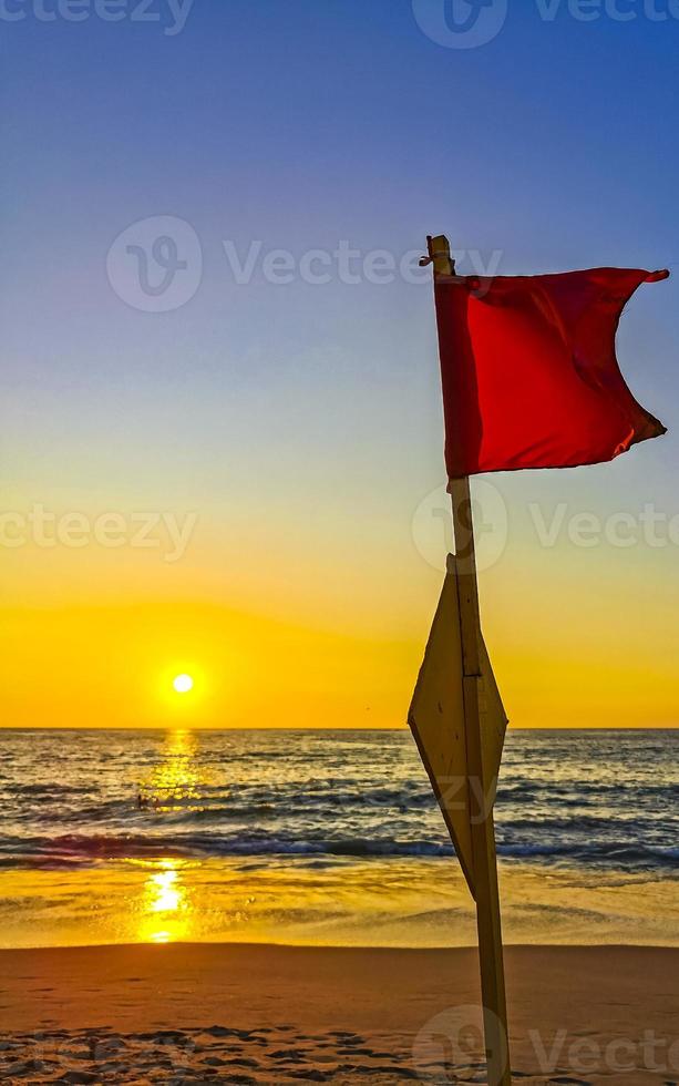 rosso bandiera nuoto Proibito alto onde con tramonto nel Messico. foto