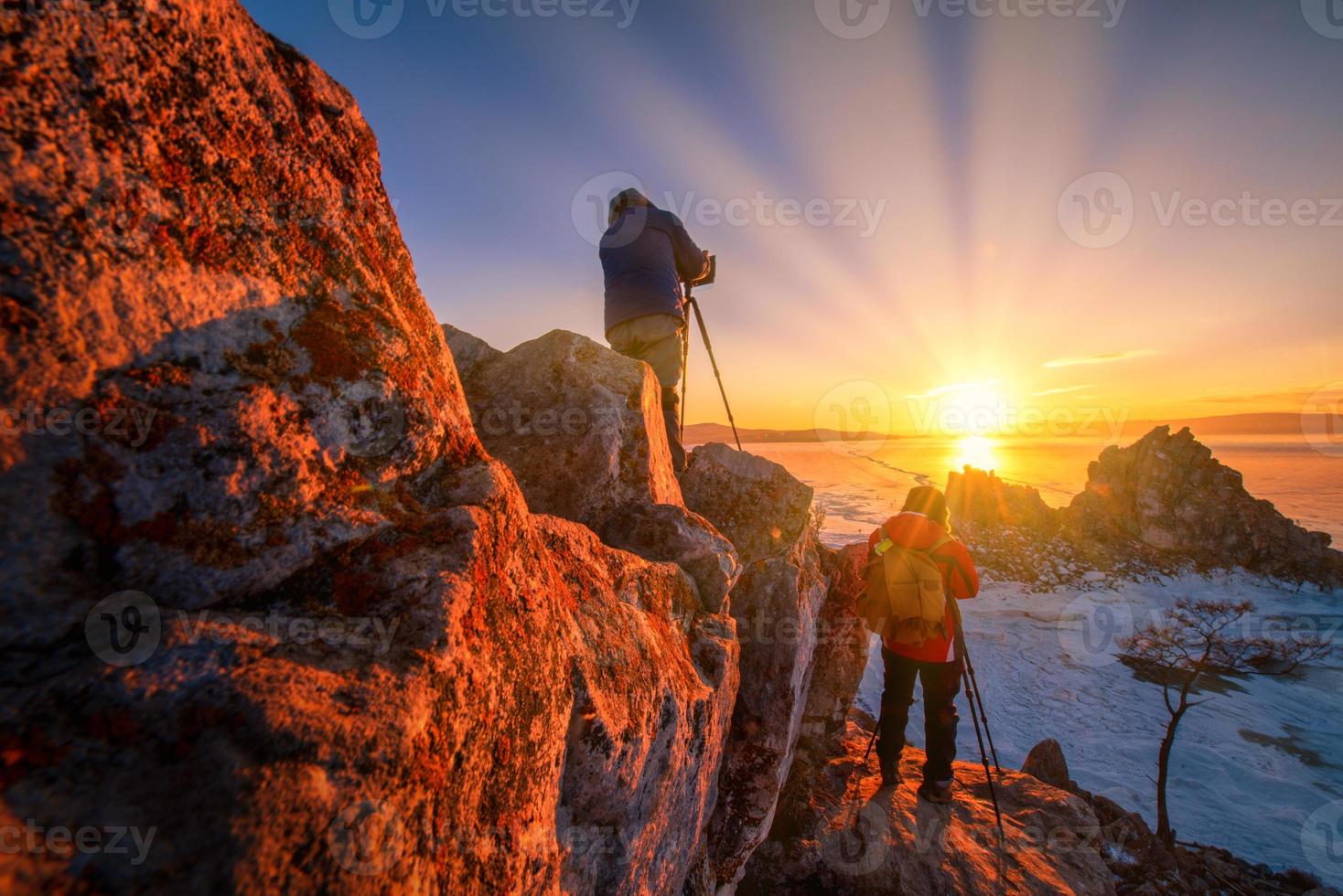 fotografo prendere foto di sciamanka roccia a tramonto con naturale rottura ghiaccio nel congelato acqua su lago baikal, Siberia, Russia.