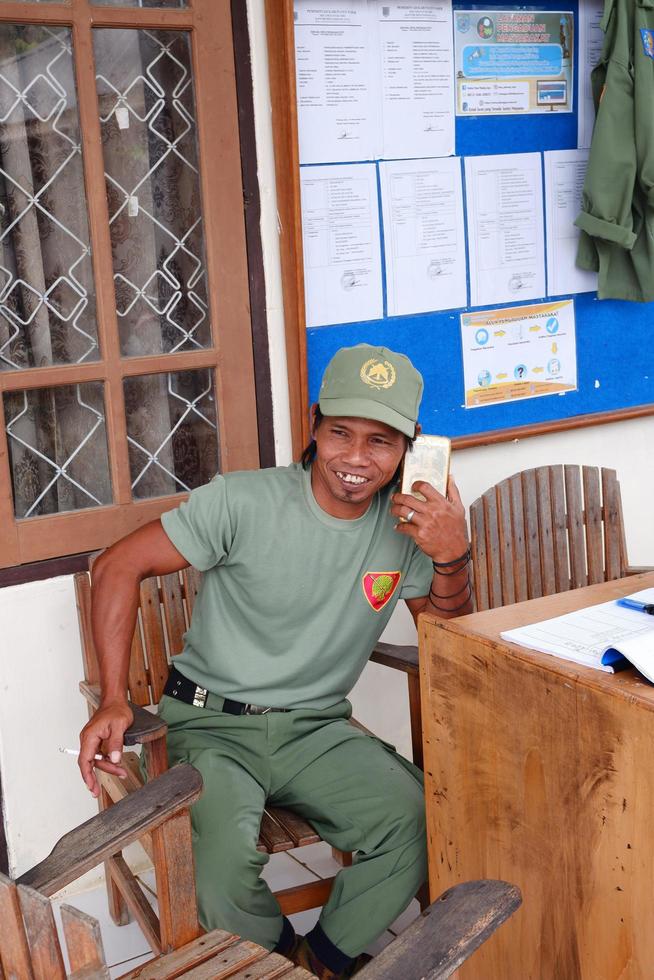 kuaro kalimantan timor, Indonesia, marzo 16, 2023. un' guardia a partire dal il villaggio di linmas era su il Telefono foto