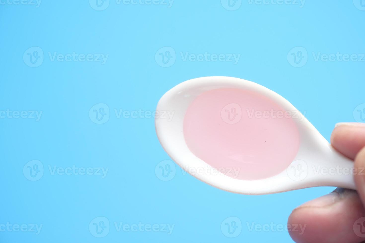 medicina liquida rosa su sfondo blu foto