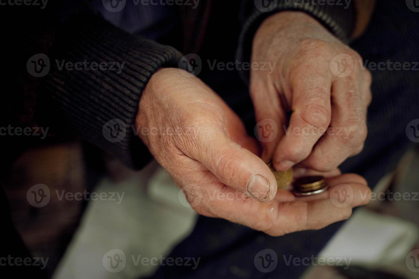 il mani di un anziano uomo prendere in considerazione piccolo le cose. concetto di povertà e Basso pensioni. foto