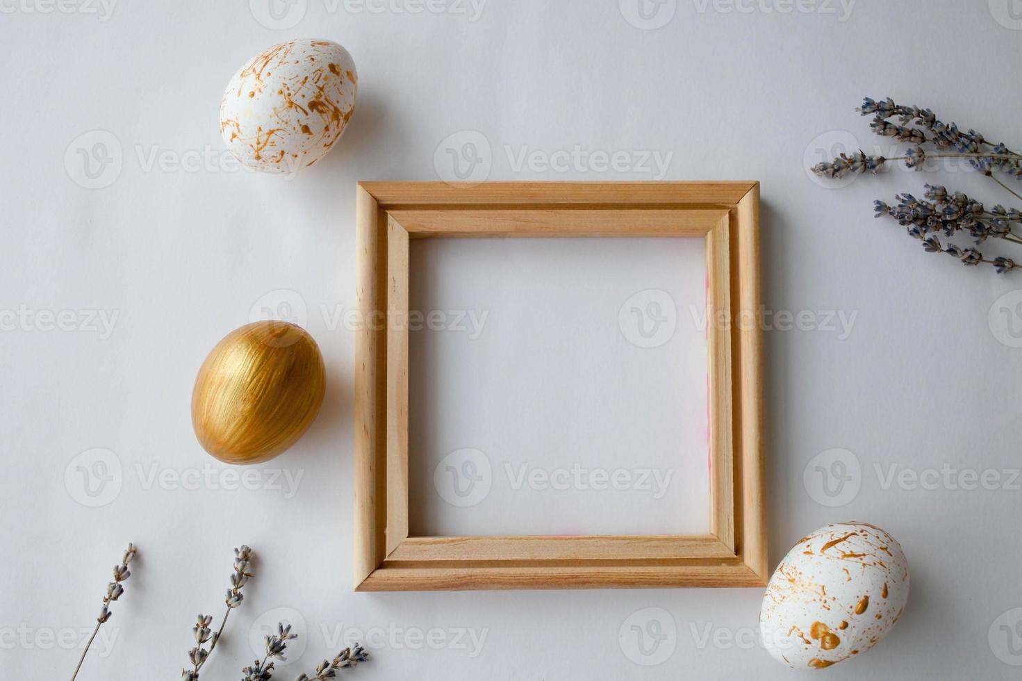 Pasqua uova su un' oro e di legno telaio sfondo su un' bianca sfondo. foto