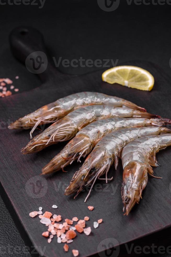 tigre gamberetto o scampi crudo con spezie e sale su un' di legno taglio tavola foto