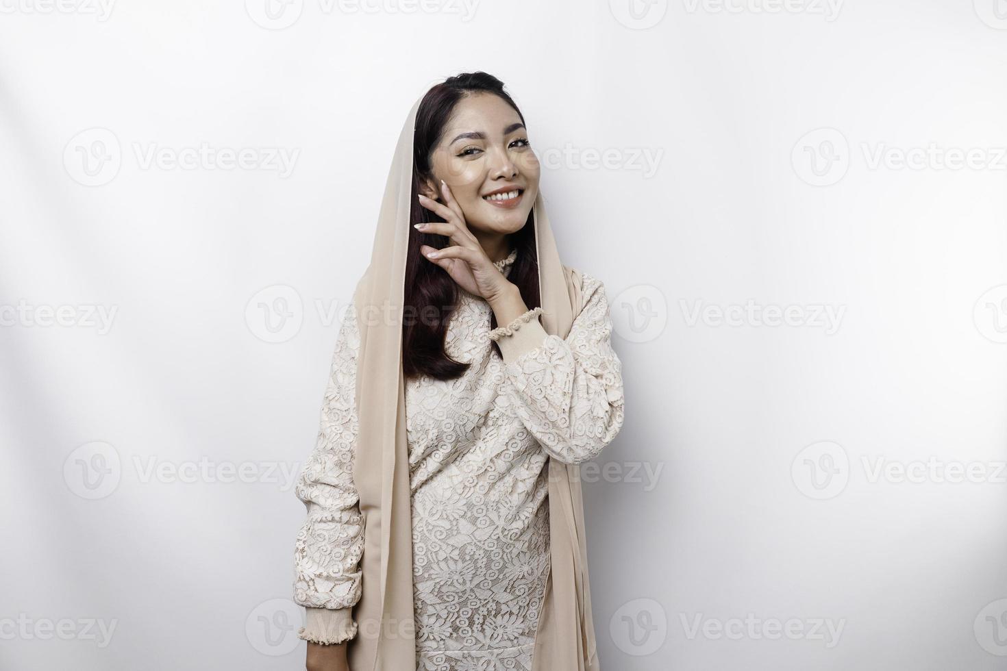 giovane asiatico musulmano donna indossare foulard sorridente per il telecamera, isolato di bianca sfondo foto