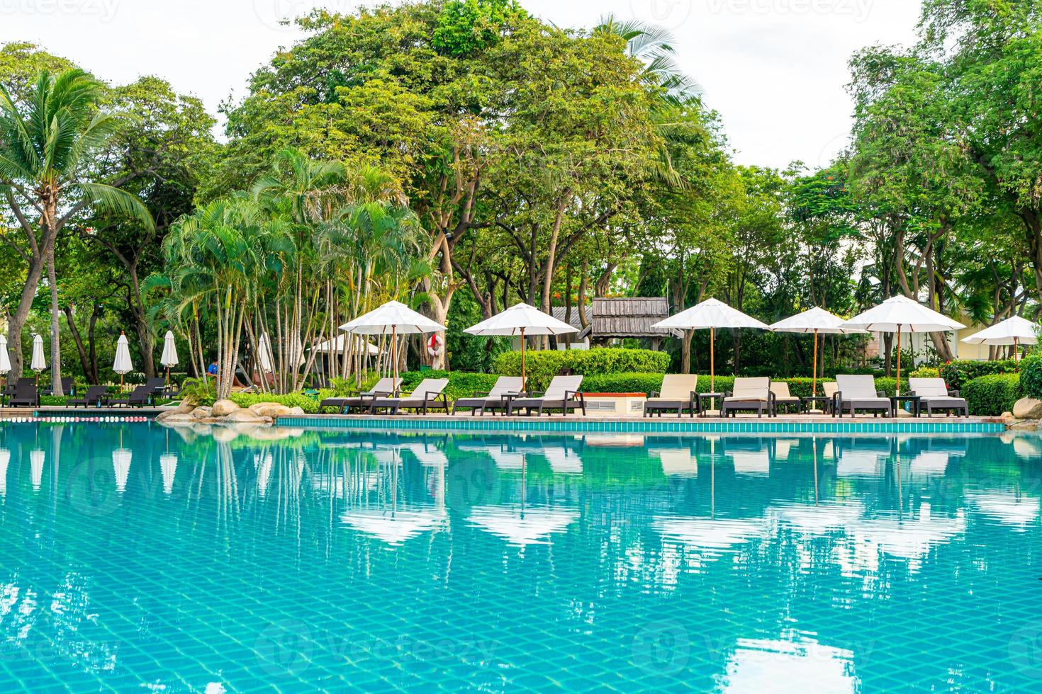 ombrellone e sedia intorno alla piscina nel resort dell'hotel foto