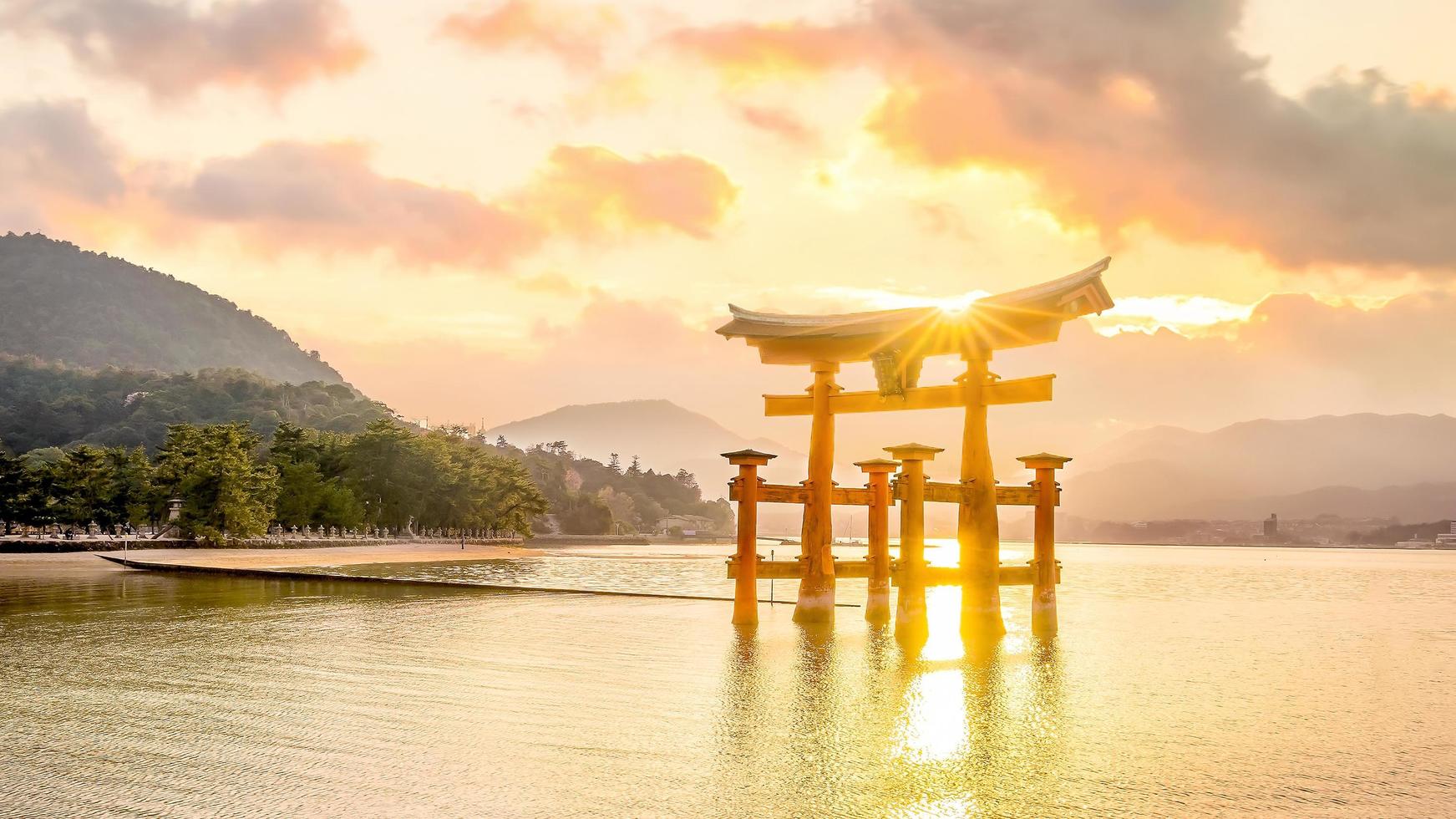 la porta galleggiante del santuario di itsukushima al tramonto foto