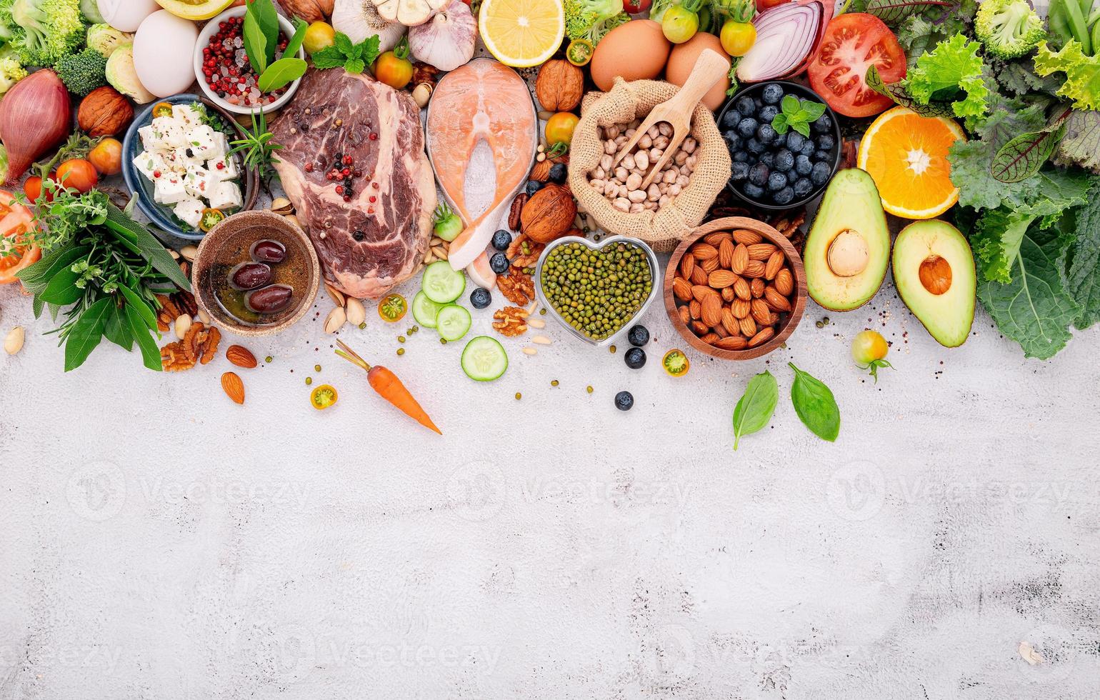 concetto di dieta chetogenica a basso contenuto di carboidrati. ingredienti per la selezione di cibi sani impostati su sfondo bianco di cemento. foto