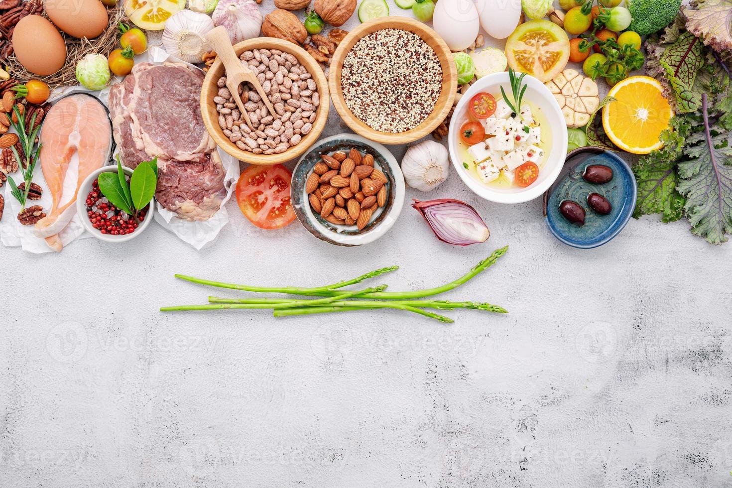 concetto di dieta chetogenica a basso contenuto di carboidrati. ingredienti per la selezione di cibi sani impostati su sfondo bianco di cemento. foto