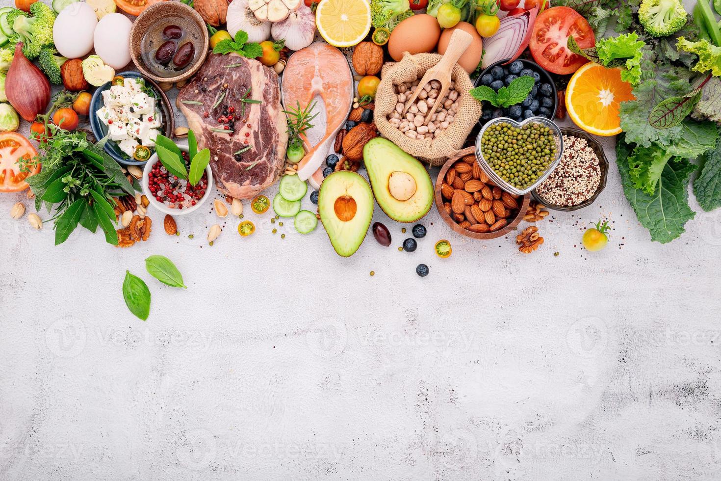 concetto di dieta chetogenica a basso contenuto di carboidrati. ingredienti per la selezione di cibi sani impostati su sfondo bianco di cemento. foto