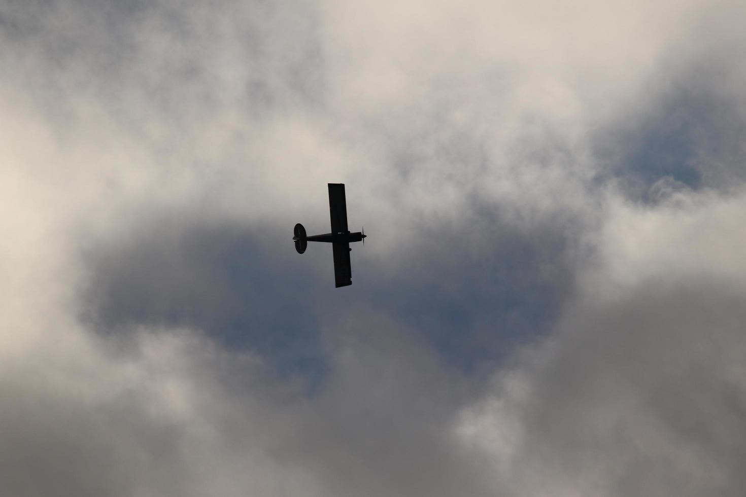 piccolo aereo volante nel il cielo contro buio nuvole foto