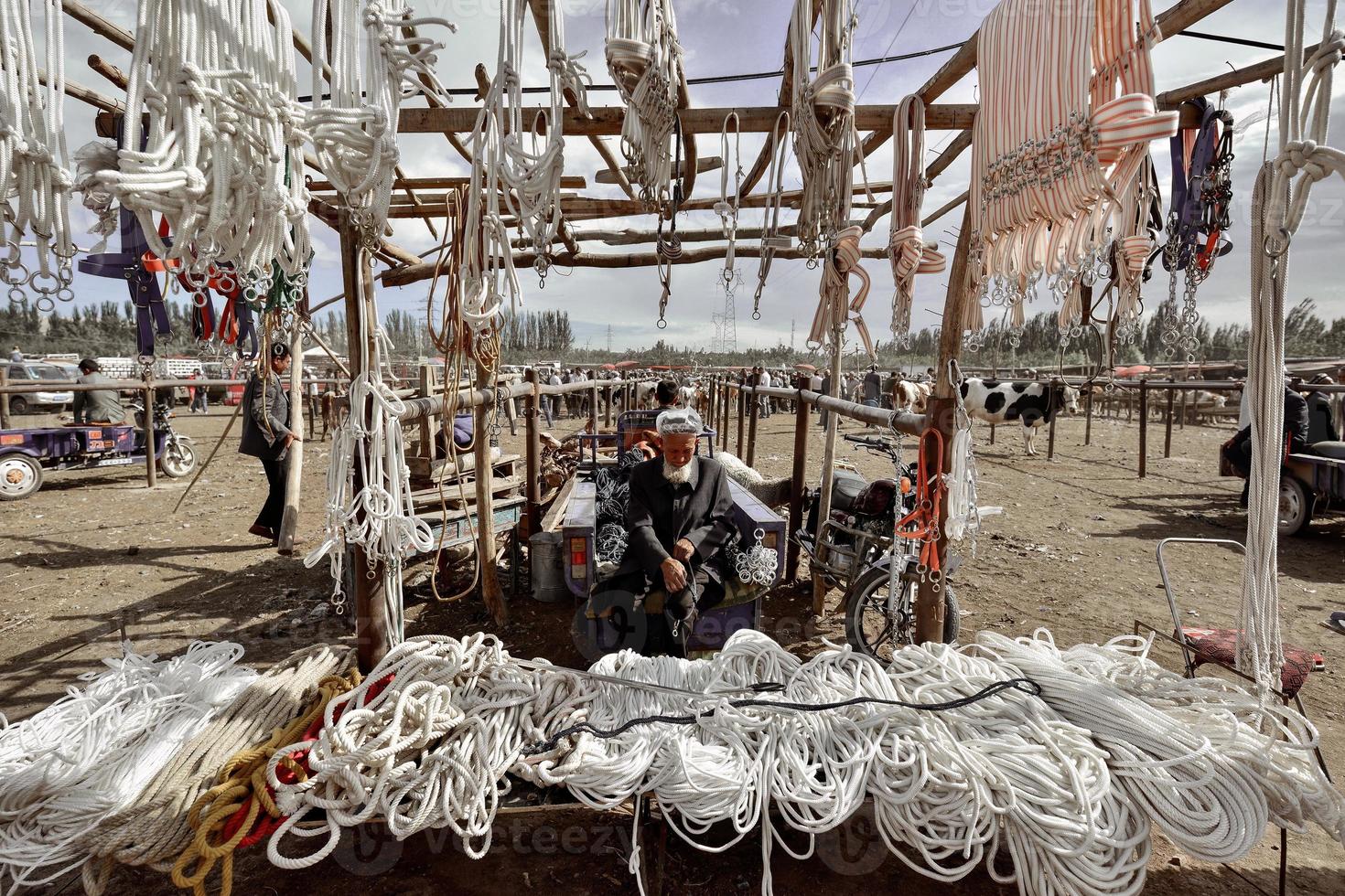 un' strada venditore vendita redini nel il bestiame e pecora bazar nel Kashgar, xinjiang foto