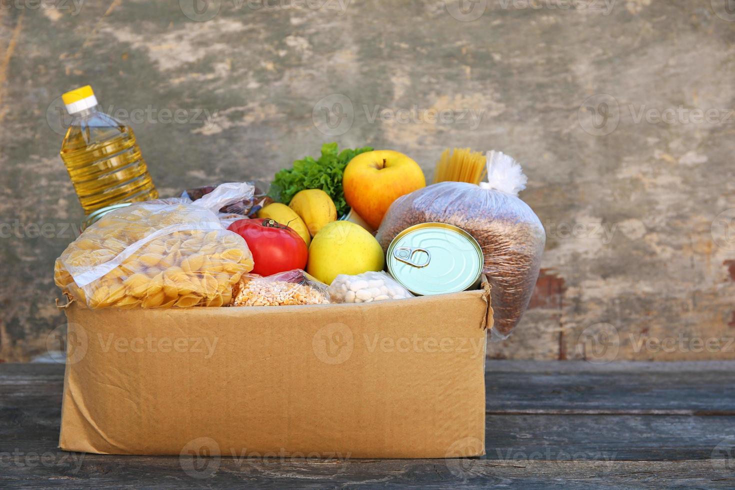 donazione scatola con cibo su vecchio di legno sfondo. foto