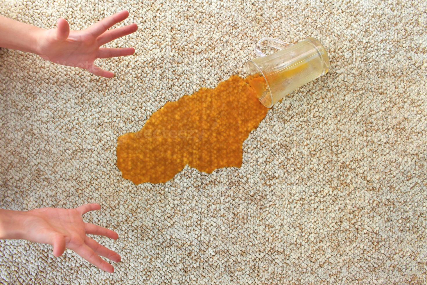 bicchiere di succo abbattere su tappeto. bevanda rovesciato su pavimento. foto