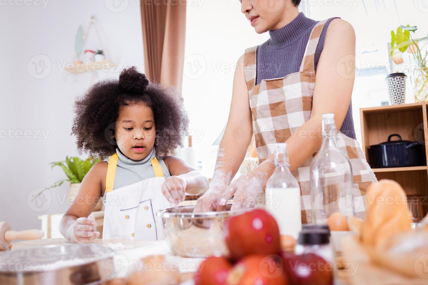 contento africano americano famiglia godere insieme mentre preparare il Farina per fabbricazione biscotti a casa foto