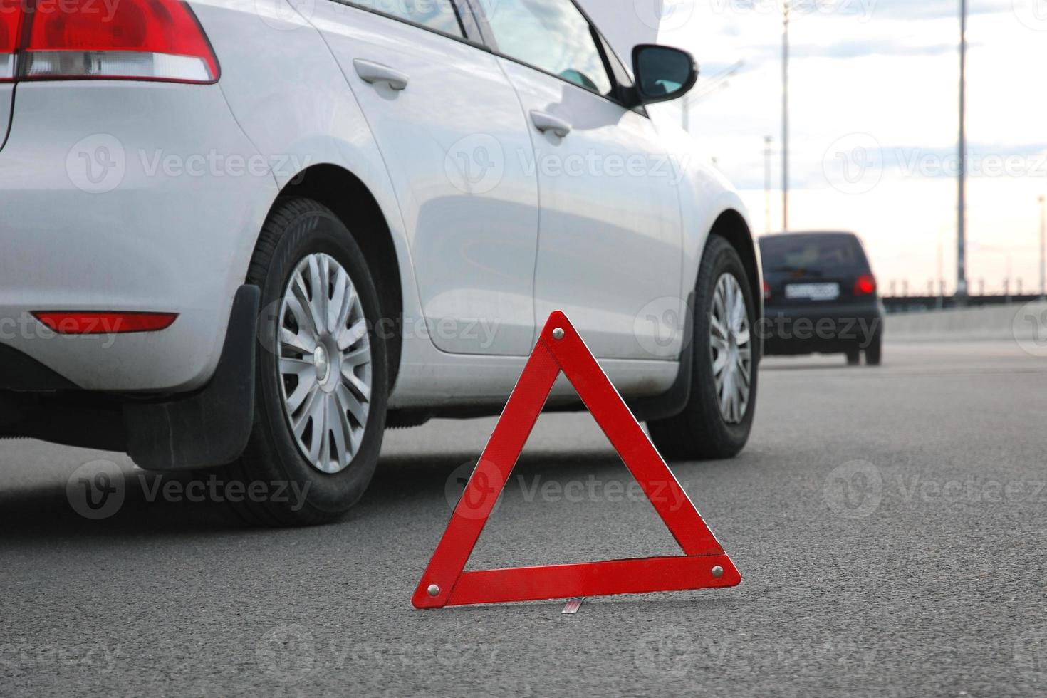 strada incidente o veicolo abbattersi - Due macchine bianca e nero fermato su autostrada dopo collisione. rosso avvertimento triangolo nel davanti di loro, Basso angolo tiro foto