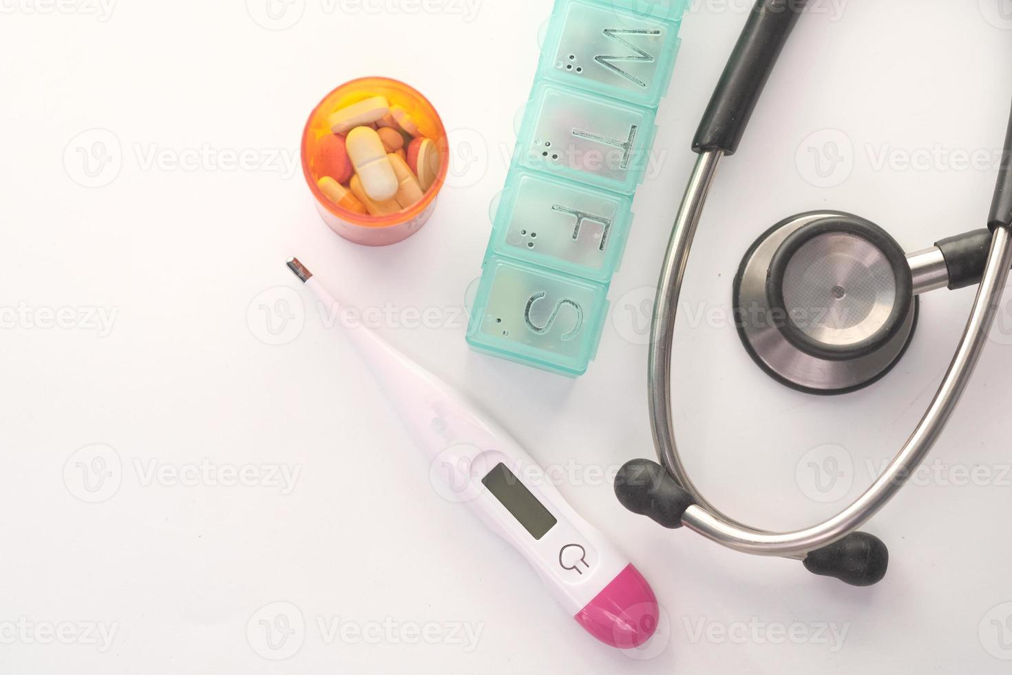 pillole, termometro e stetoscopio su sfondo bianco foto