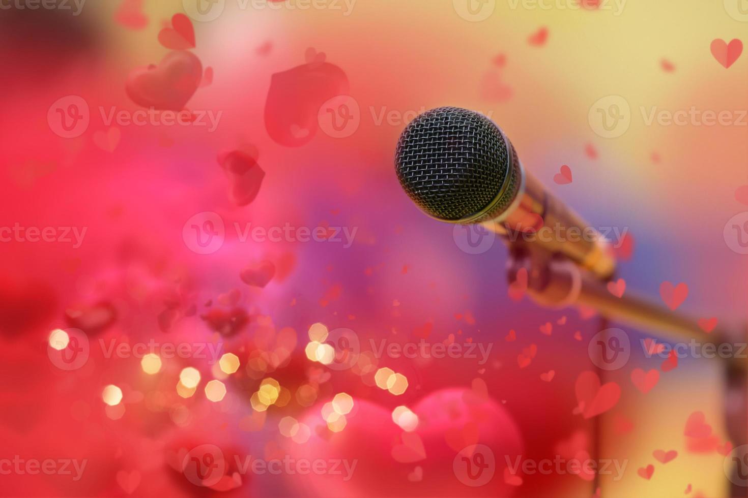 palcoscenico d'oro microfono su il sfondo di rosso San Valentino cuori e d'oro bokeh. foto