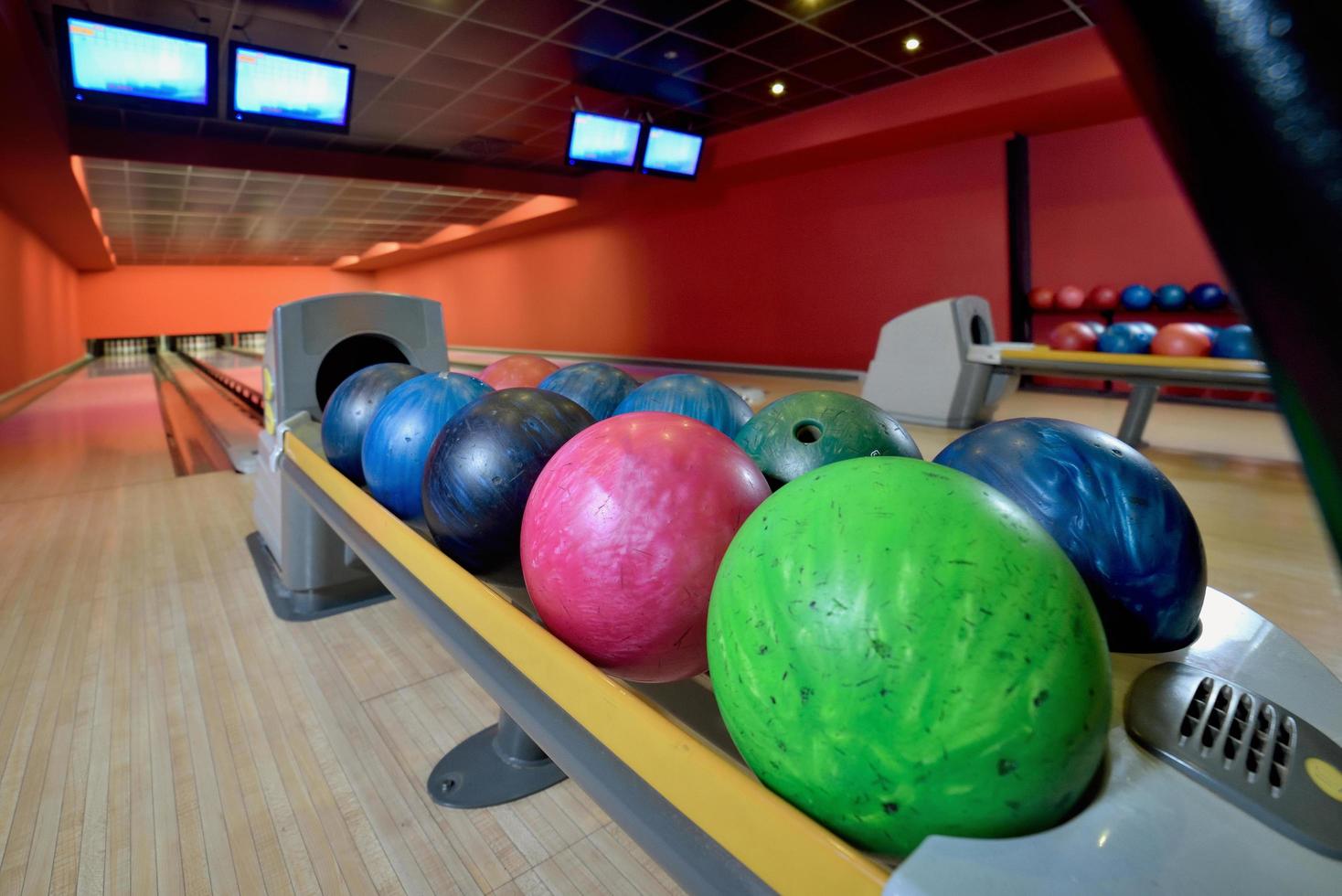 palle da bowling e piste di legno in una sala da bowling foto