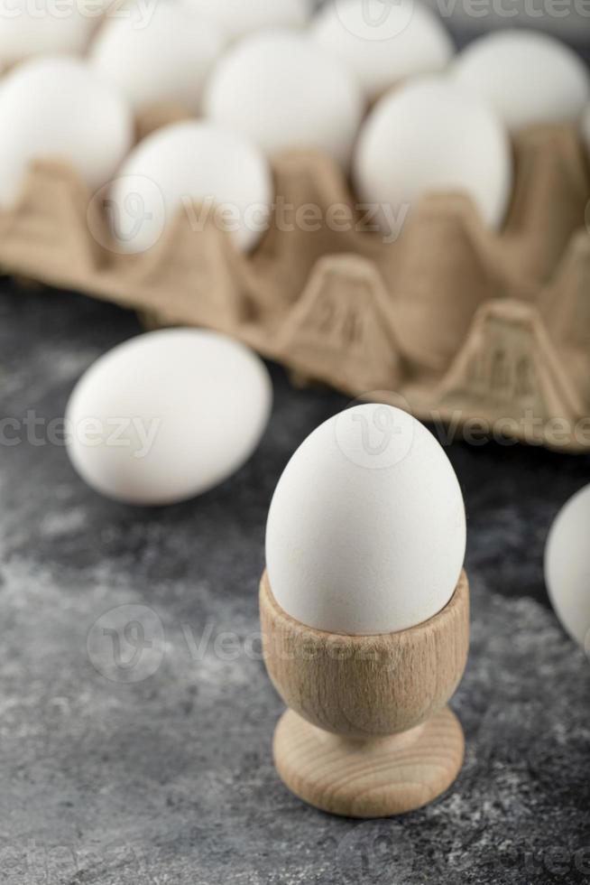 un portauovo di legno con un uovo di gallina bollito foto