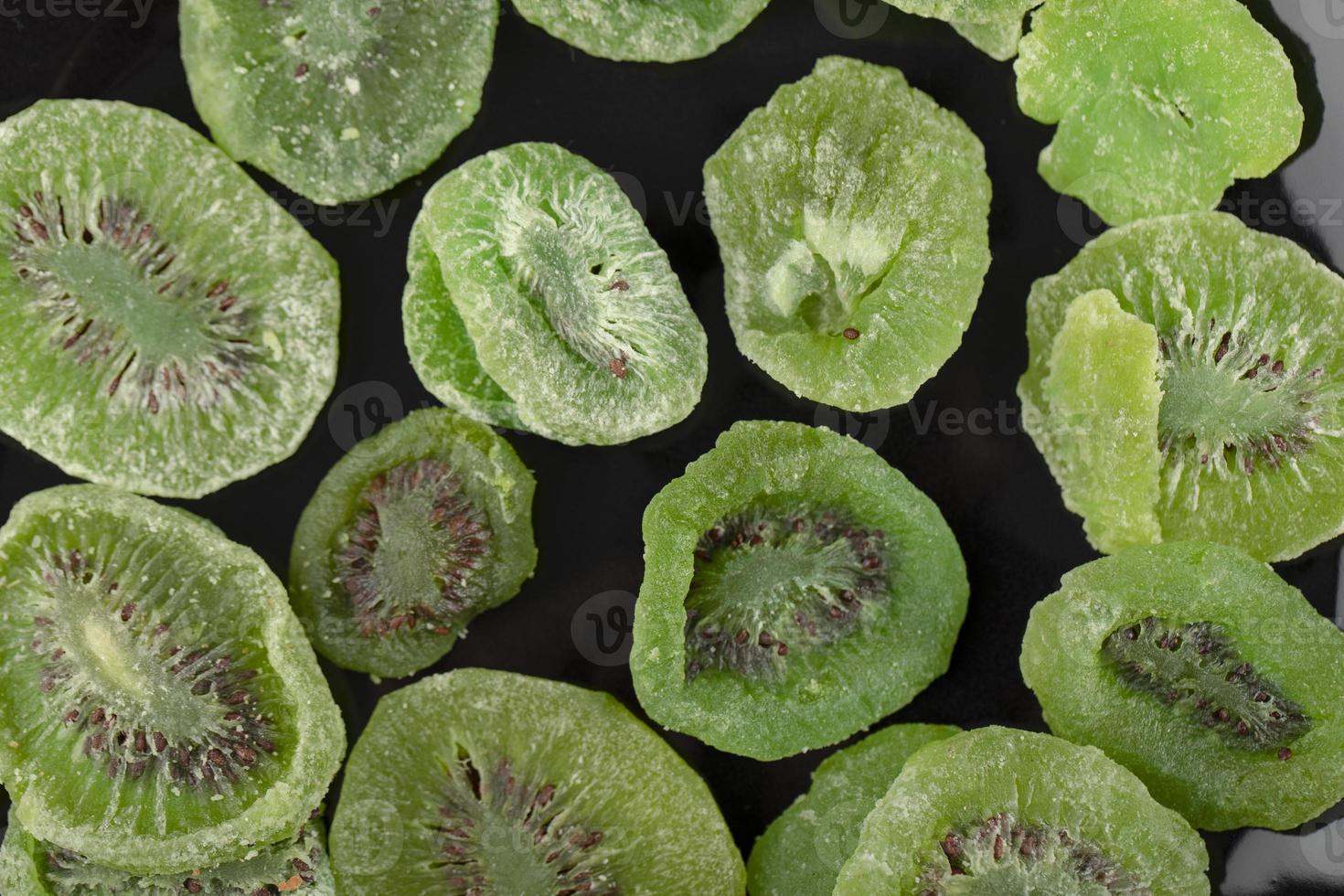 fette di kiwi essiccate su un piatto nero foto