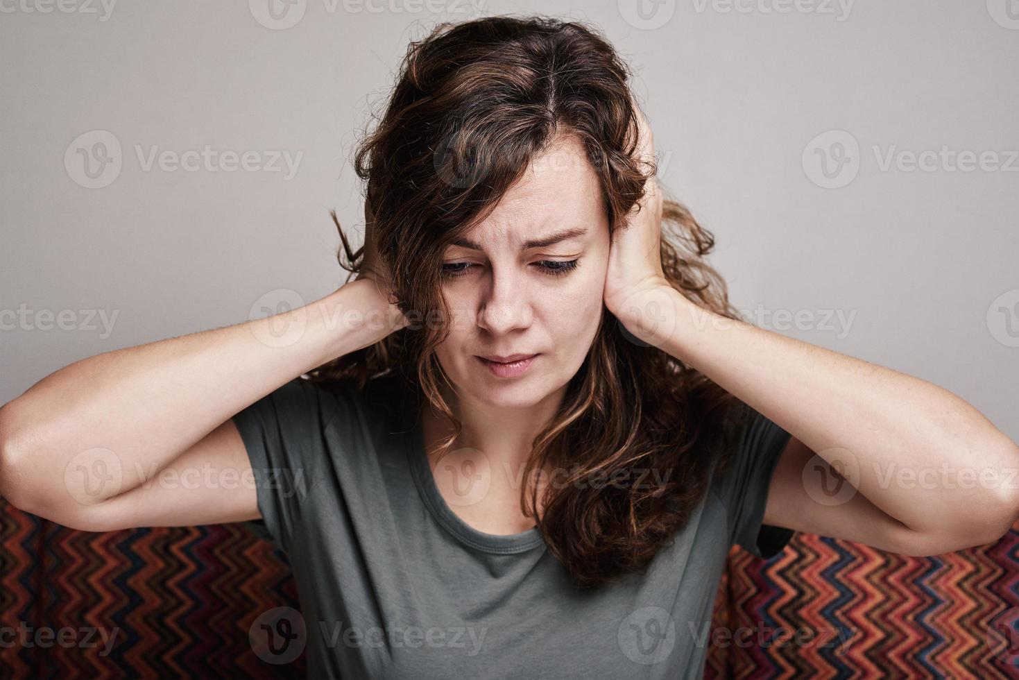 donna coperto sua orecchie con mani, forte testa dolore foto