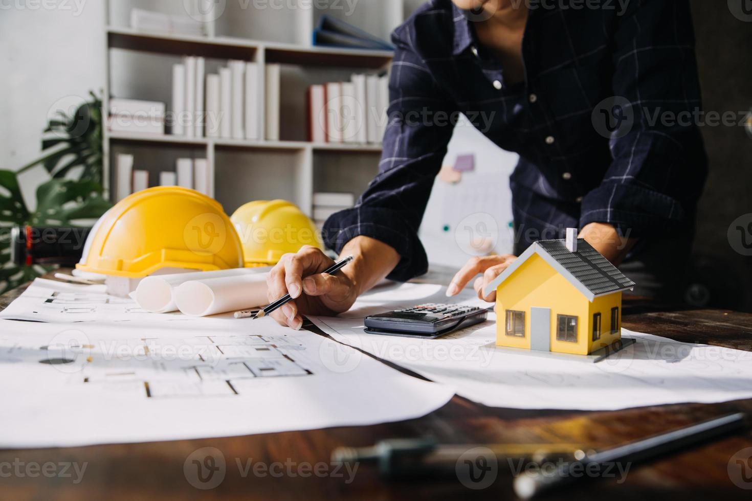 costruzione e struttura concetto di ingegnere o architetto incontro per progetto Lavorando con compagno e ingegneria utensili su modello edificio e planimetria nel Lavorando luogo, contrarre per tutti e due aziende. foto