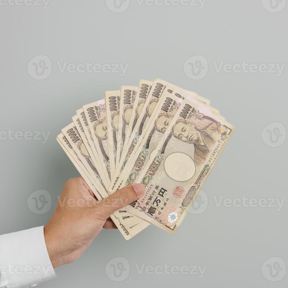 uomo mano Tenere giapponese yen banconota pila. mille yen i soldi. Giappone Contanti, imposta, recessione economia, inflazione, investimento, finanza e shopping pagamento concetti foto