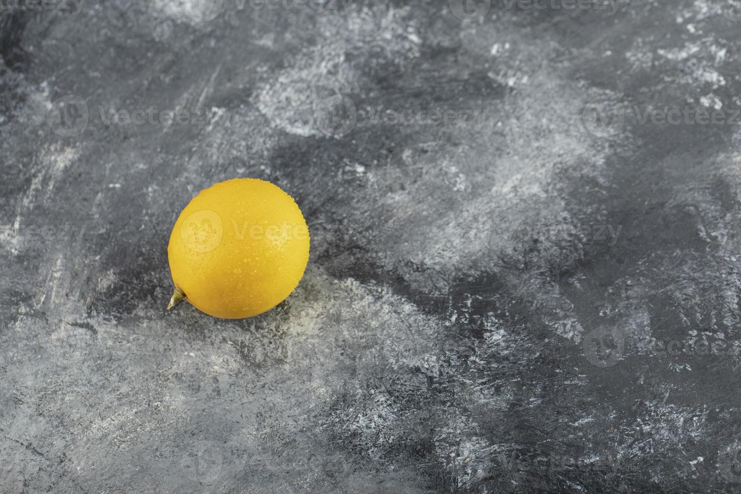 un giallo limone maturo su uno sfondo di marmo foto